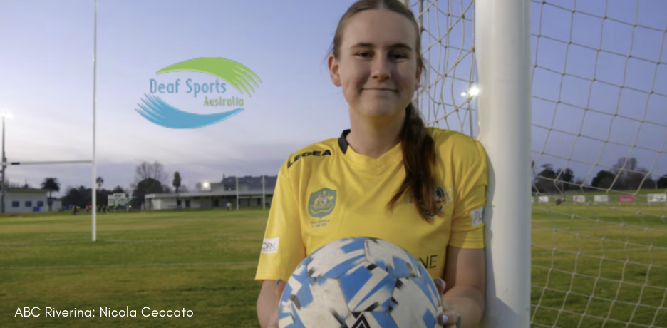 Image shows Ruby Miller in a yellow shirt holding a soccer ball and leaning against a soccer goal. There is the Deaf Sports Australia logo next to her. At the bottom of the image, it states "ABC Riverina: Nicola Ceccato"