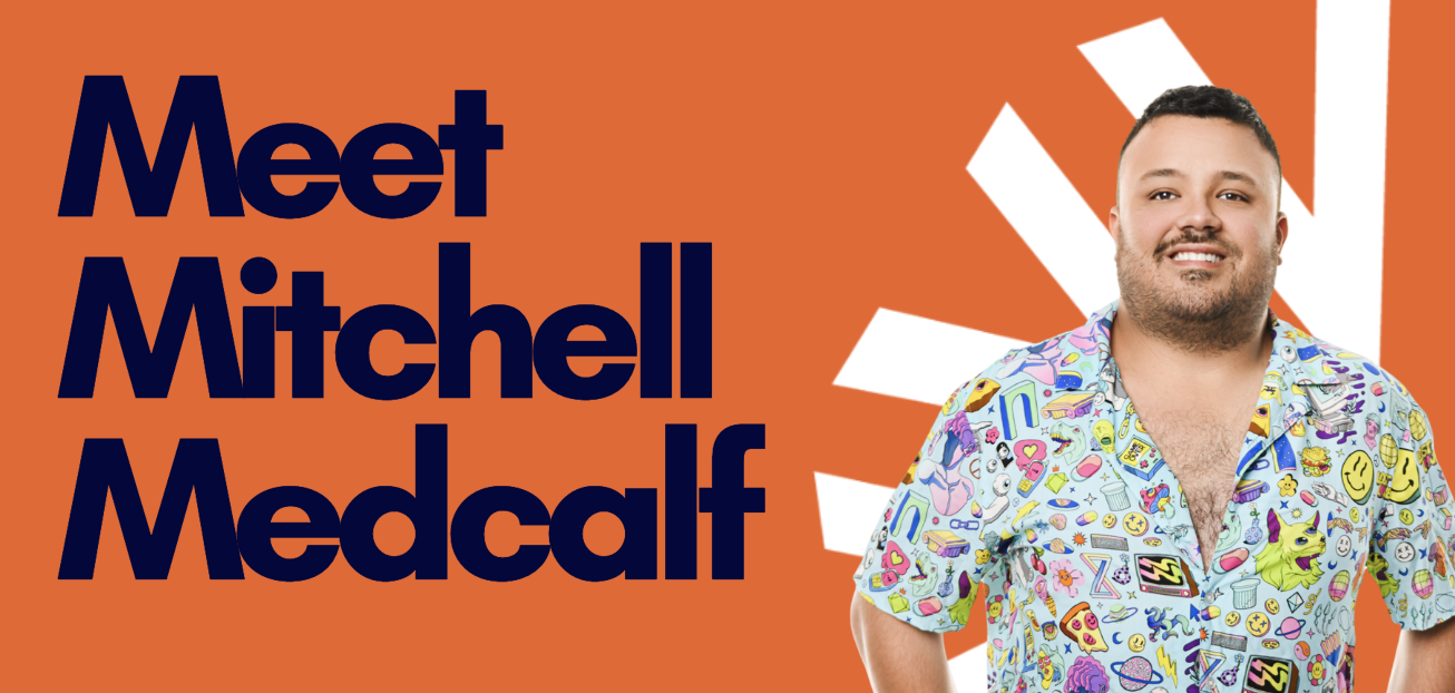 Graphic with bold navy text on an orange background reading “Meet Mitchell Medcalf” on the left, and on the right a person with their face blurred wearing a colorful, cartoon-patterned button-up shirt standing in front of a white radial sunburst design.